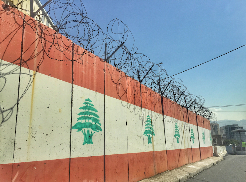 Military fence with Lebanese flag and barbed wire in Beirut, Lebanon (Source: Shutterstock)